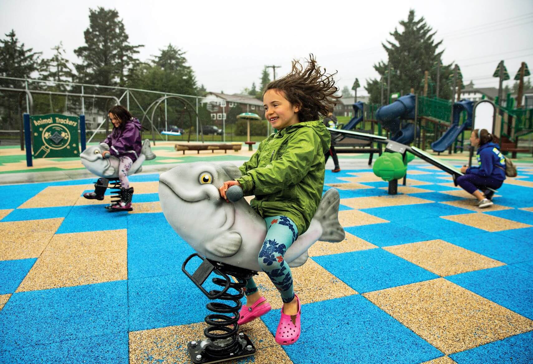 A child enjoys playtime on safe playground surfacing.